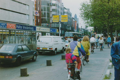 861774 Afbeelding van het drukke fiets- en autoverkeer aan de noordzijde van het Vredenburg te Utrecht, met links ...